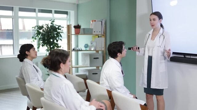 Qualified female doctor conducts a training lecture for medical professionals. Medical students on advanced training, they sit in the classroom and listen to a presentation. High quality 4k footage