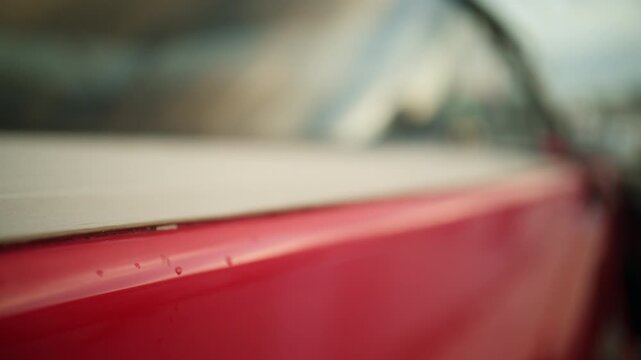 Low angle blurred view of the red side of a yacht docked at Port Vauban in Antibes, with calm marina water