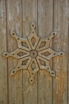 Rustic wooden carving with symmetrical pattern on aged plank wall