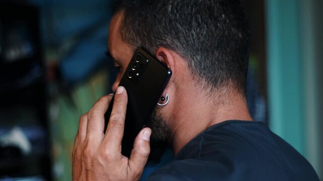 Man Talking on a Smartphone in profile in a Casual Indoor Setting
