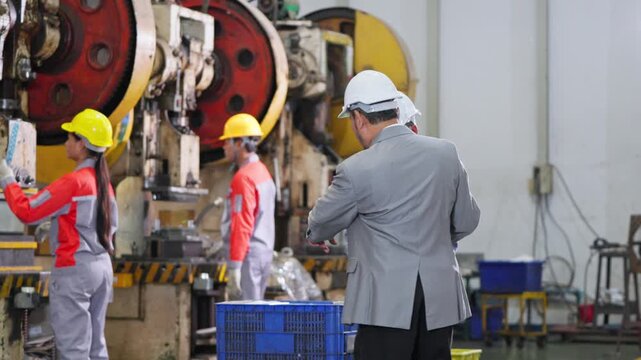 Managers collaborating in an industrial space discussing project strategies and plans in a factory setting