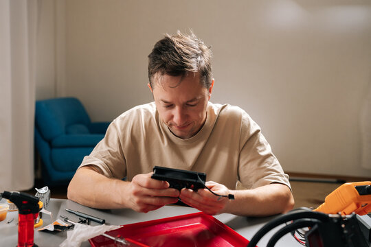 Pensive young adult technician male repairing and installing computer liquid cooling system, showcasing pc building, technical support. Concept of computer hardware maintenance and upgrade.