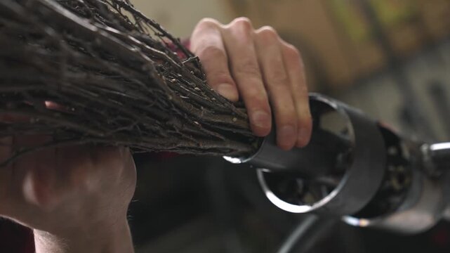 The decorator inserts tree branches into a metal frame to create a flying broom.
