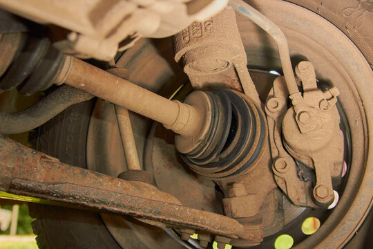 Car CV joint and suspension close up, Dusty CV joint boot and car suspension details