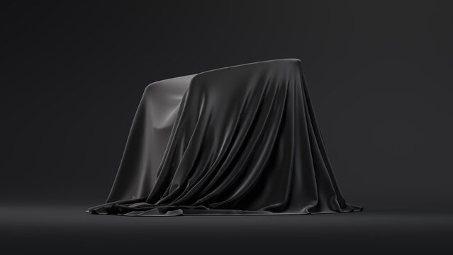 A dark, draped fabric-covered object sits on a plain black surface against a solid black background. Copy space. 