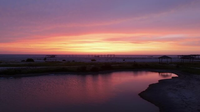 vibrant purple and orange sunset over tidal pool