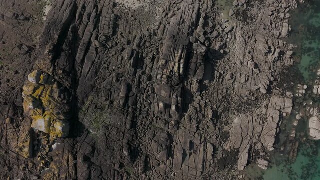 Aerial top-down view of rocks, sand and clear water at Chausey, France