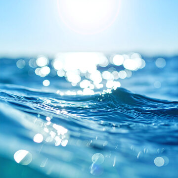Sparkling blue ocean water glistens under the bright summer sun in this serene, closeup abstract shot. Nobody is present, evoking feelings of pure peace and tranquil holiday vibes.