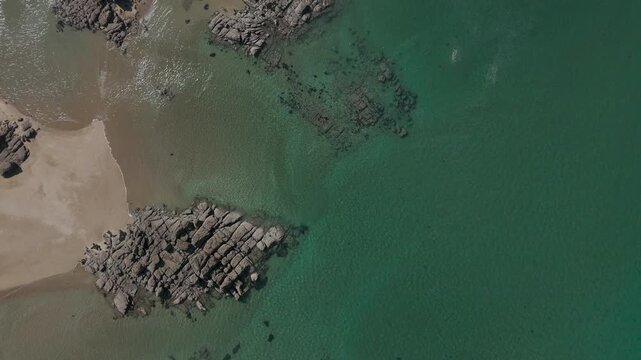 Aerial top-down view of rocks, sand and clear water at Chausey, France