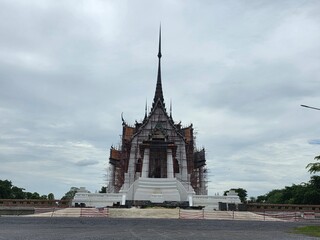 Obraz premium Grand Temple Structure Under Construction: An impressive, intricately designed temple structure, adorned with traditional spires and ornate details, stands tall against a cloudy sky.