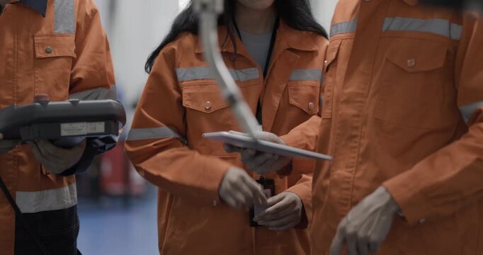 Female and Male engineers checking or maintenance electronic in AI or artificial intelligence robot arm in the manufacturing automation and robotics manufacture room. Service technical engineer. 
