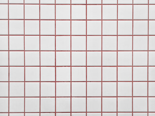 Background of minimalist white ceramic tile wall texture with bright red cement grout. Surface of white checkered tile pattern with red grout lines has modern Scandinavian for retro minimalist look. © Windi Holly