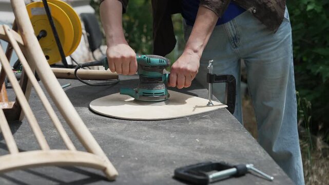 Woman sanding and restoring an antique wooden chair in village, home renovation and handmade craftsmanship