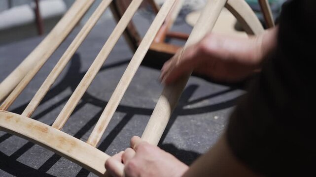 Woman renovating an old wooden chair, sustainable furniture restoration and upcycling