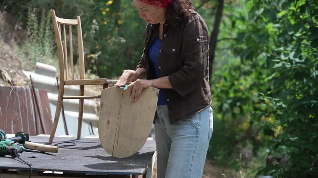 craftswoman refurbishing an old wooden chair, furniture repair, restoration and woodworking
