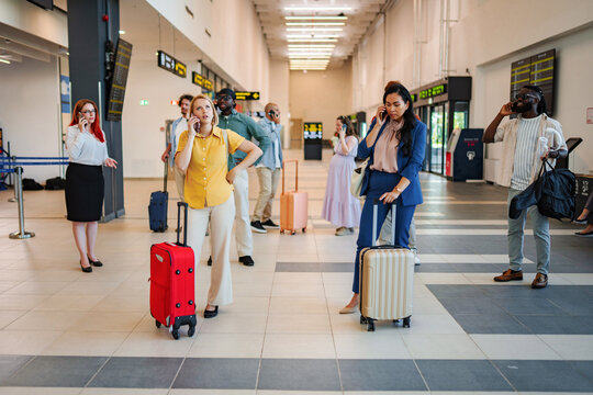 Stressed travelers making phone calls in airport terminal
