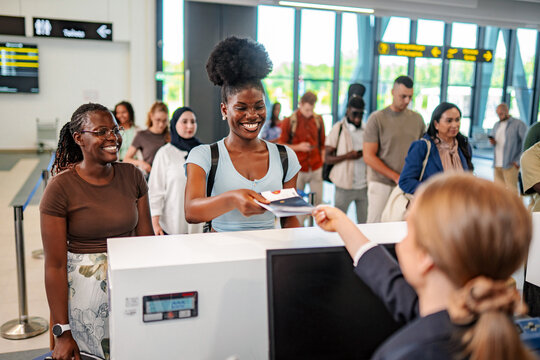 Young adult woman checking in at airport counter