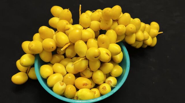 fresh healthy Ripe raw Yellow Dates Fruit Cluster Served On bowl Top View Composition