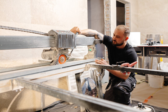 Construction worker cutting tile with tile saw during renovation works