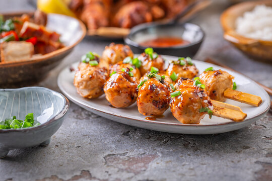 Deliciously grilled meat skewers served with tangy sauce and fresh green onions