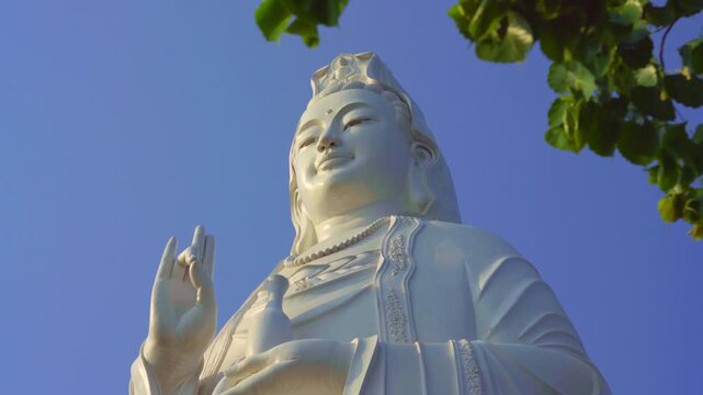 Majestic long shot of the iconic Lady Buddha statue towering against a clear blue sky in Da Nang, Vietnam, symbolizing peace and spirituality.