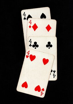 A hand of vintage playing cards isolated on a black background.