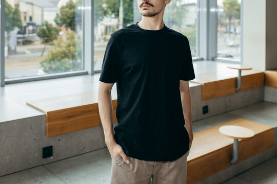 Man wearing black blank t-shirt with space for your logo or design. Mock up	
