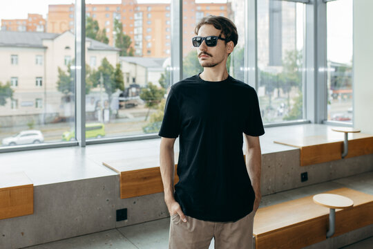 Man wearing black blank t-shirt with space for your logo or design. Mock up	
