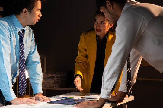 Brainstorming meeting with colleagues to discuss planning business projects together. Group of ambitious startup businessmen are analyzing strategies and planning while working overtime in the office.