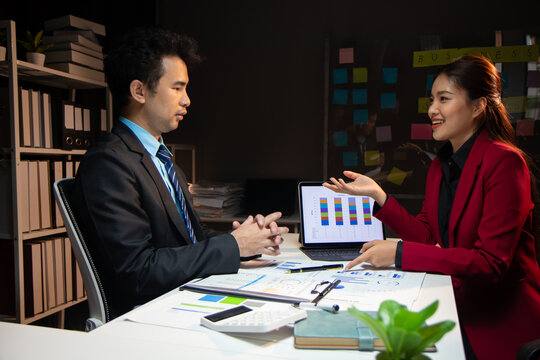 Meeting with business consult is discussing analysis of financial reports and market share situation to plan strategy. Discussion of financial chart analysis to plan profit maximization.