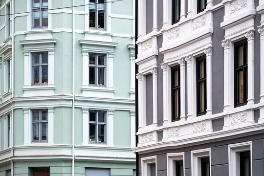 Along a quiet street in Gr&uuml;nerl&oslash;kka, pastel facades reveal ornate windows and residential architecture within the layered streetscape of Oslo, Norway.