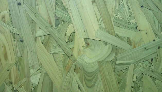 A detailed high-resolution close-up view of oriented strand board (OSB) featuring a rugged, textured surface composed of compressed wood flakes and chips, showcasing natural timber grain patterns.