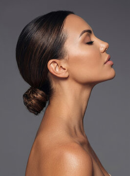 Elegant side profile portrait of a beautiful woman with her dark hair styled in a sleek low bun