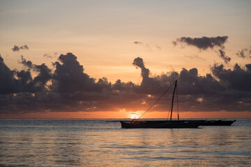 Tradycyjne Zanzibarskie drewniane katamarany na oceanie Indyjskim w świetle wschodżącego  słońca © kubikactive