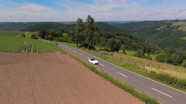 Convertible Cars Driving on Scenic Winding Road in Luxembourg