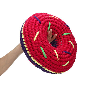 Premium object shot of eco friendly woven cotton donut pillow with sweet sprinkles pattern. Creative minimalist design element with copy space for handicraft workshop advertising banners.