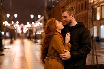 Fototapeta premium Man and a woman are hugging each other on a street