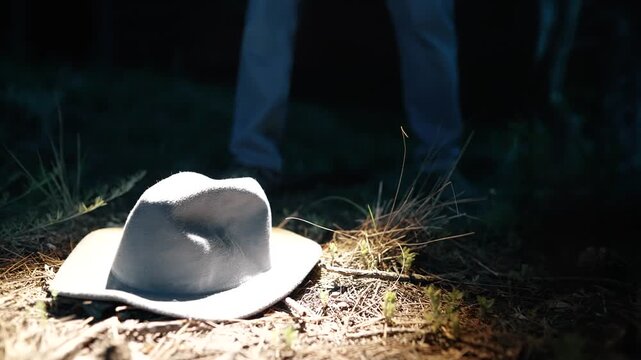Detective in forest at night with flashlight finding and studying a clue