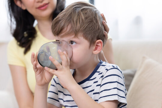 Mother and son sharing a moment while he drinks milk from a glass in their home