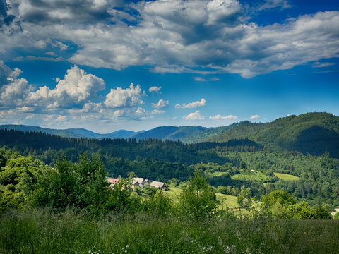 Sunny Carpathian peaks: green valleys and cloudy white skies.