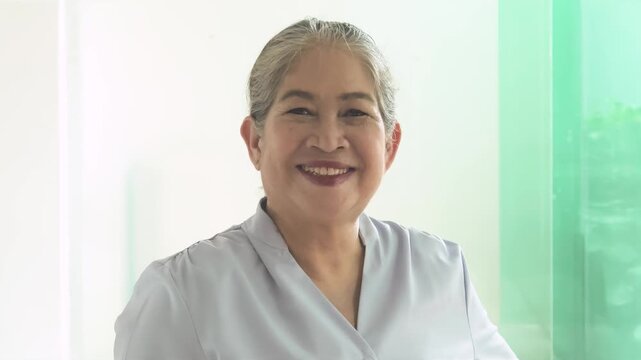Happy smiling middle aged asian woman with positive friendly expression in urban environment