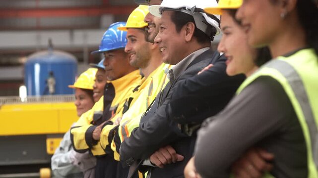 Multi-ethnic group of corporate leaders and factory technicians celebrating a successful deal in a manufacturing plant. Perfect for annual corporate reports, international trade commercials, and ESG s