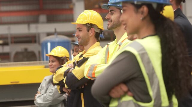 Multi-ethnic group of corporate leaders and factory technicians celebrating a successful deal in a manufacturing plant. Perfect for annual corporate reports, international trade commercials, and ESG s