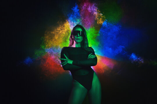  Portrait of fashion young girl in cool sunglasses in red and blue neon light in the studio