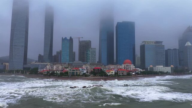Aerial view of massive waves pounding urban coastline when typhoon arrives
Storm surge and rough seawater crash against the city coastal embankment