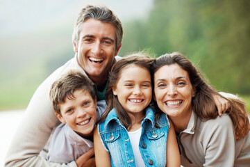 Obraz premium Portrait, nature and happy family with hug for outdoor bonding, holiday or adventure together. Dad, mom and children with smile or embrace in wilderness for travel, weekend trip or vacation in forest