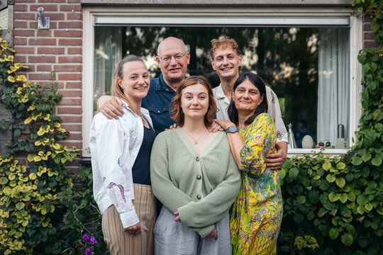 Happy family gathered in a garden outside their home