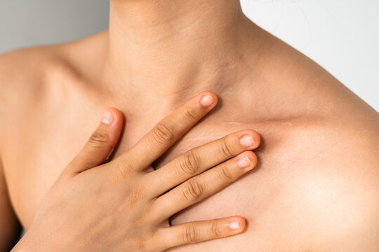 An unrecognizable woman applying moisturizer to her chest. Skin