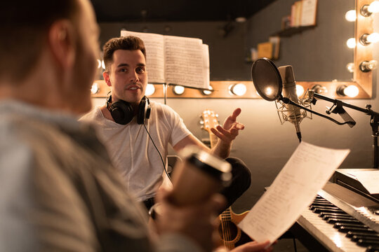 Man discussing song with friend. Men in sound studio