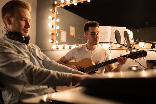 Adult men recording song in studio. Musicians in sound studio